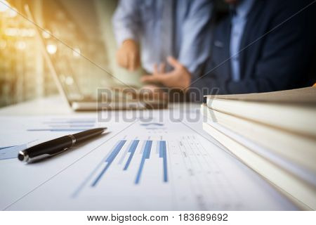 Teamwork process Blur background Young businessmen hands pointing at tablet laptop and document during explanation of new plan project data at meeting.