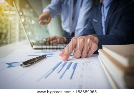 Teamwork process Businessmen hands pointing at laptop and document during explanation of new plan project data at meeting.