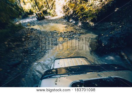SUV cross the mountain river in forest. View from the hatch of the car. Tourist expedition Gelendzhik Russia