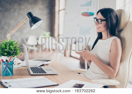 Inspired Young Brunette Girl Is Thinking About Weekend That Is Coming While Drinking Coffee At Work
