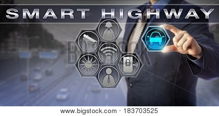 Blue chip corporate manager is plugging an automobile icon into a SMART HIGHWAY monitoring interface. Information technology concept for traffic management mobility management and smart integration.