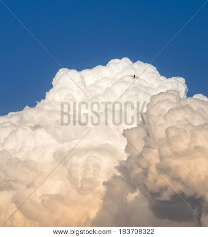Storm clouds and a distant airplane. Early evening sky at sunset.