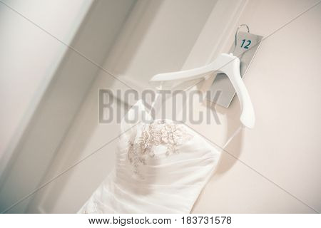 White dress of bride on hanger, symbol nubile, beautiful luxury cream wedding dress for bride