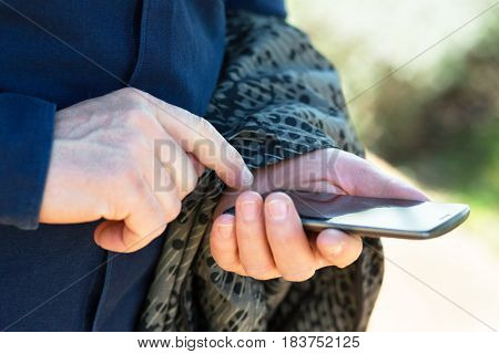 Mock up of a man holding and using device and touching screen outdoor. Smartphone in male hands closep.
