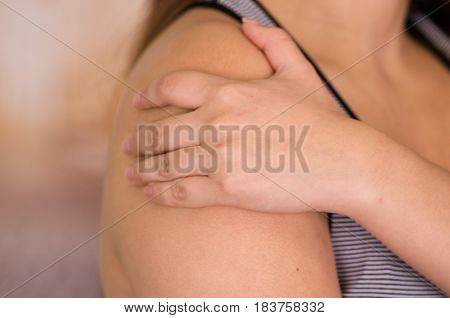 Young woman suffer from a shoulder pain.