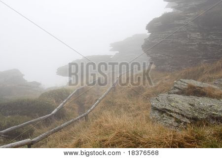 Percorso e Rock nella nebbia sul colle superiore di nome Vozka (Cartman) (montagne di nome Jesenik in Repubblica Ceca