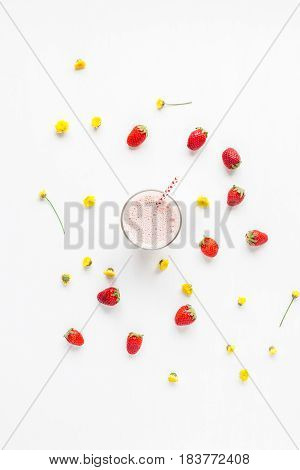 Strawberry milkshake fresh strawberry and yellow flowers on white background. Summer concept. Flat lay top view