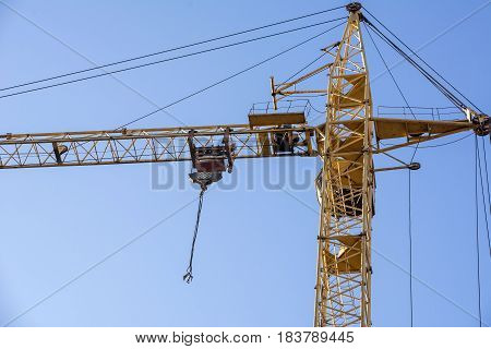 yellow construction crane on a background of blue sky.