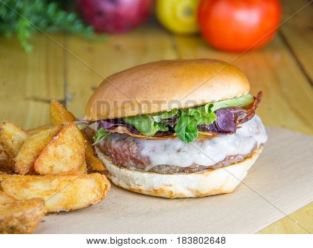   Burguer with onion jam, crispy bacon and provolone with potatoes.