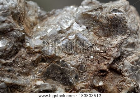 Macro photo of weathered mica minerals in coarse grained quartz rock.
