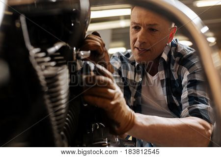 Need some strength. Accomplished mature precise expert looking delighted having spotted an untied bolt and fixing it using special wrench