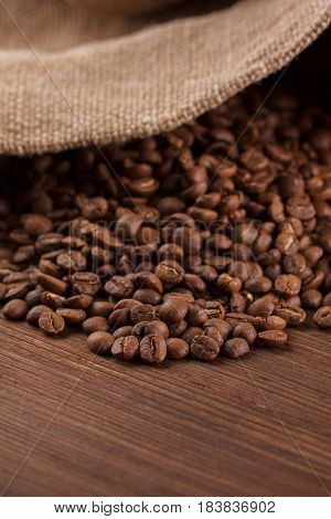 Coffee Is Poured From A Burlap On A Wooden Background