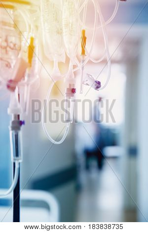 Dropper in a vein close-up. Doctor in the background in the defocus. Blue background. The concept of body cleansing.high contrast and monochrome color tone.