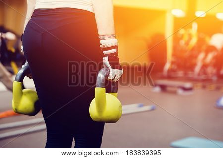 Close-up girl is Training with a dumbbell in the gym.concept of fitness