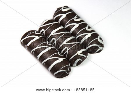 Three chocolate glazed cookies isolated on white background, close-up