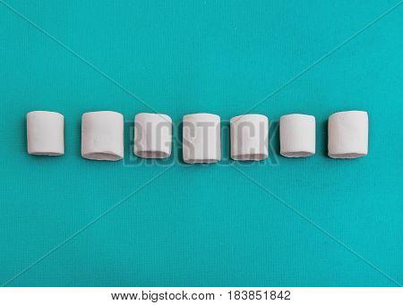 Marshmallows Background or texture of colorful mini marshmallows Seven white marshmallows are lying on a blue background