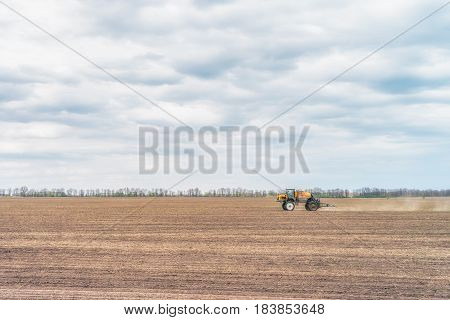 KREMENCHUK, UKRAINE - APRIL 22, 2017: Tractor preparing the field before seeding the ground. Wheat - main crops, which are grown in Ukraine