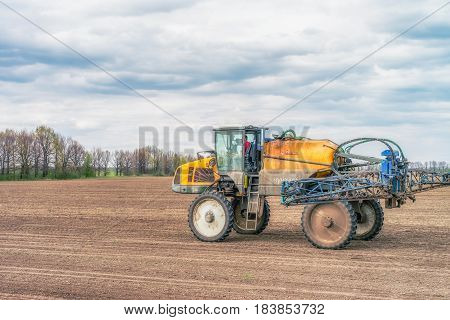 KREMENCHUK, UKRAINE - APRIL 22, 2017: Tractor preparing the field before seeding the ground. Wheat - main crops, which are grown in Ukraine