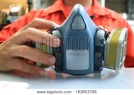 Multi-purpose respirator half mask for toxic gas protection.The man prepare to wear Multi-purpose respirator half mask.