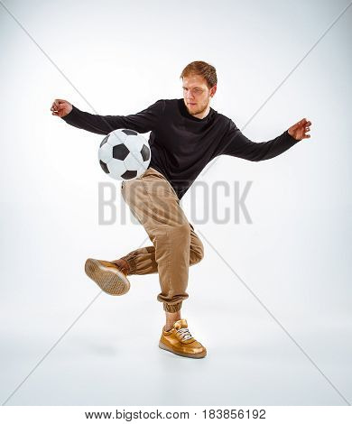 A portrait of a fan with ball on gray studio background. Freestile concept