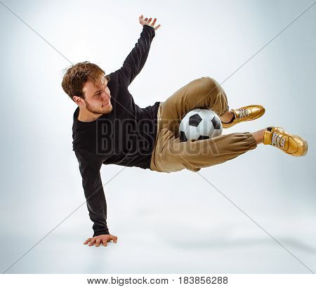 A portrait of a fan with ball on gray studio background. Freestile concept