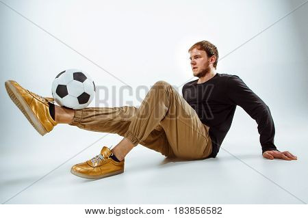 A portrait of a fan with ball on gray studio background. Freestile concept