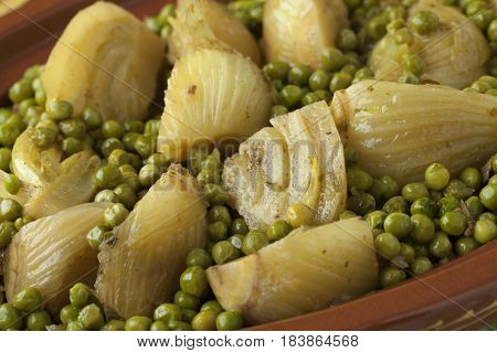 Traditional Moroccan tagine with meat, peas and fennel close up 