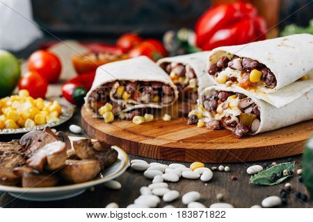 Nice Vegetarian Burrito Over Black Table On Wooden Board.