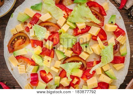 Tortilla With Salad Over It, Surrounded By Ingredients.