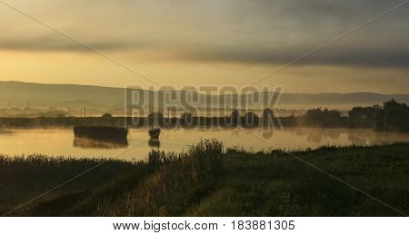 Sunrise over the fishpond on foggy morning, Romania