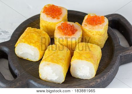 Rolls With Caviar In An Omelette On A Wooden Board