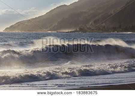 Beautiful stormy seascape at sunset time with mountain on background