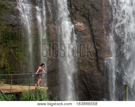 Girl with blonde hair near waterfall, sri lanka