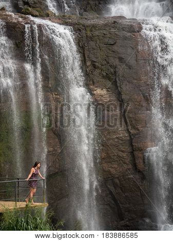 Girl with blonde hair near waterfall, sri lanka