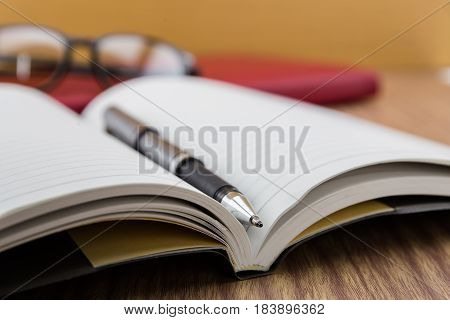 Book With Pen, Mobile And Keyborad On Desk