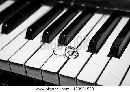 Wedding rings on piano black and white
