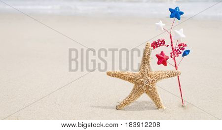 Independence Day USA background background with starfishe and decorations on the sandy beach near the ocean/American patriotic concept