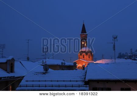 Gece görüş karlı çatılar ve ışıklı kilise Madonna Moretta Alba, İtalya.