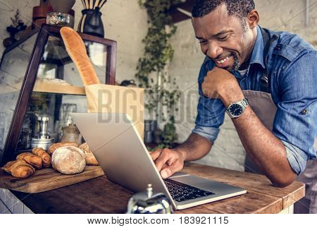 Man using devices for online business order at bakehouse