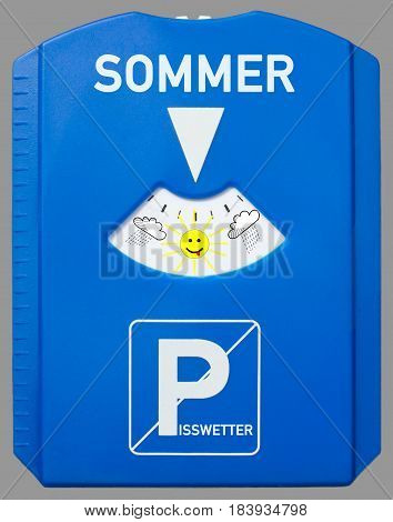 A german parking disc with the german words for summer and bad weather isolated on grey