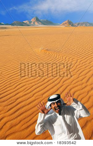 Hombre árabe tradicional riendo, haciendo cara divertida y jugando peek a boo en el desierto de Wadi Rum, Jord