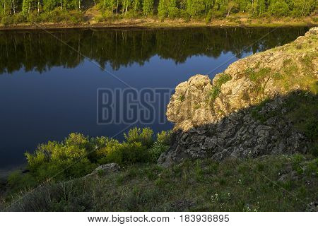 Summer landscape on the river. An unusual rock illuminated by the morning light.