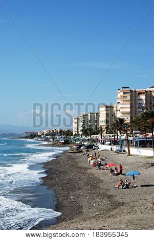 TORROX COSTA, SPAIN - OCTOBER 27, 2008 - Tourists relaxing on the beach with the promenade and apartments to the rear Torrox Costa Malaga Province Andalusia Spain Western Europe, October 27, 2008.