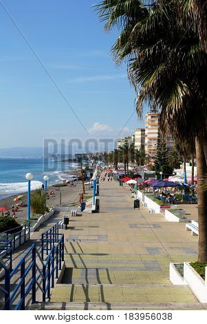 TORROX COSTA, SPAIN - OCTOBER 27, 2008 - Tourists walking along the promenade with pavement cafes to the right hand side and the beach to the left Torrox Costa Malaga Province Andalusia Spain Western Europe, October 27, 2008.