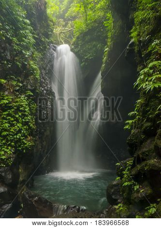 Jungle landscape with flowing turquoise water of Erawan cascade waterfall at deep tropical rain forest. Indonesia