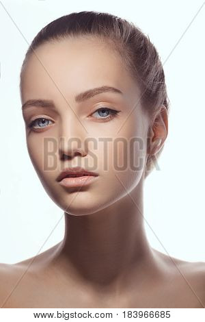 Beautiful face of young teen woman with clean fresh skin. Close-up portrait of young caucasian model with perfect skin. Attractive girl looking at camera against white background