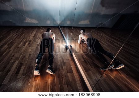 Attractive Muscular Man Doing Push-ups On A Wooden Floor.