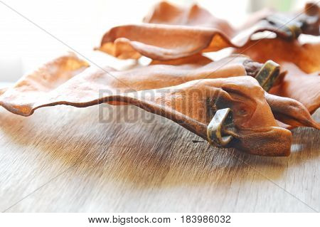 pet snack dried ear cow with loop for sure real meat on wooden board