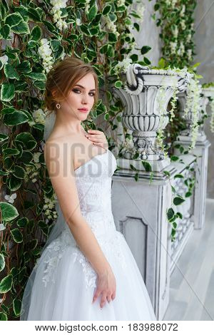 Beautiful young bride in a luxury dress in elegant interio