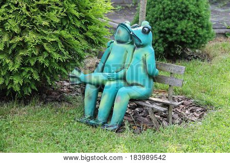 Schodnica Ukraine - June 30 2014: Decorative funny frogs sitting on bench in city park